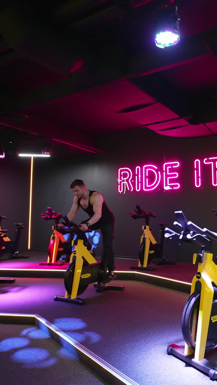 Young man working out on bike. Attractive man riding exercise bike in the gym