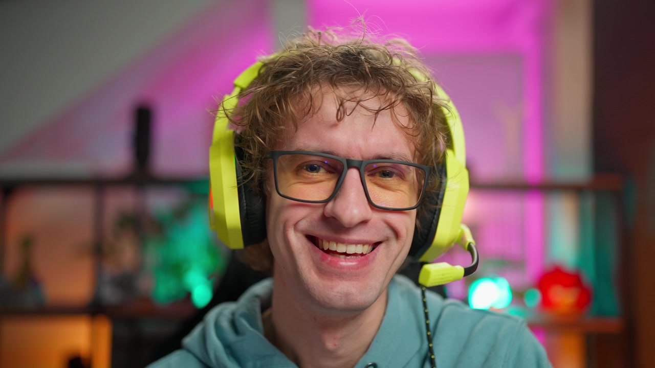 Giovane uomo con cuffie da gaming che parla e sorride alla telecamera