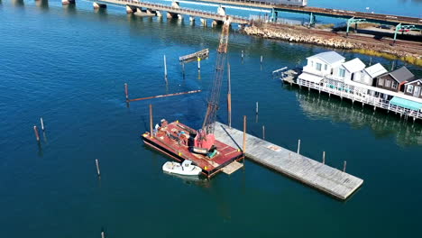 un lapso de tiempo aéreo sobre una draga en una barcaza atracada en una bahía cubierta de hierba en queens, nueva york