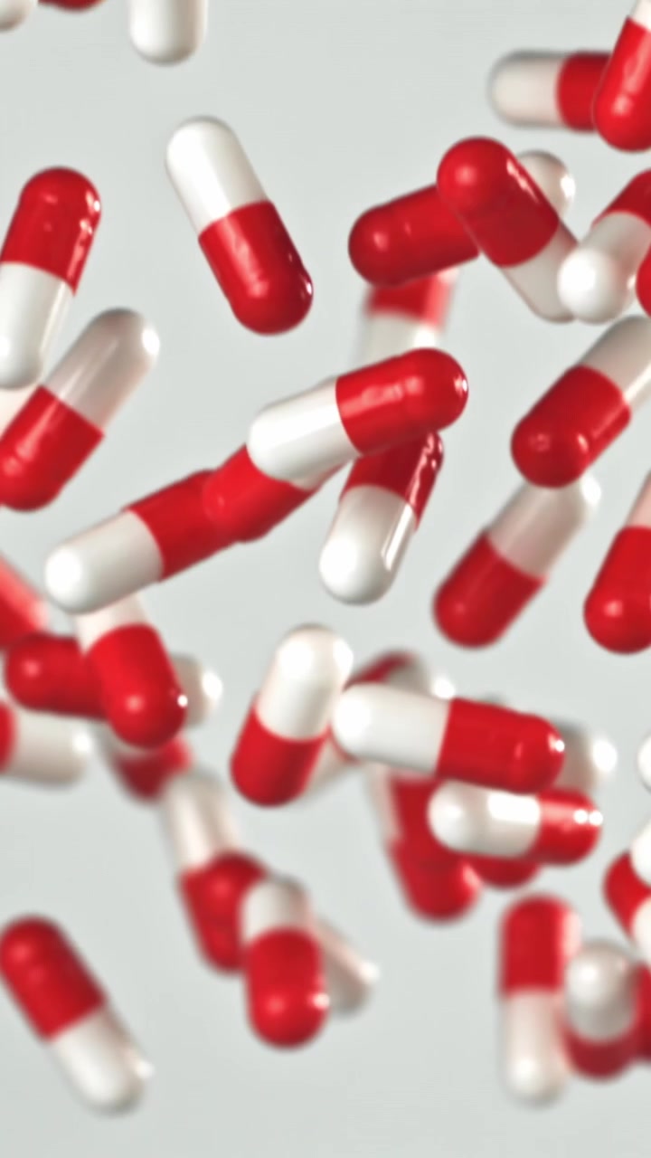 Capsule mediche rosse e bianche che cadono al rallentatore