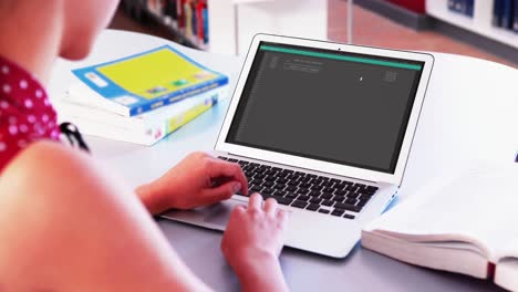mujer caucásica sentada en un escritorio codificando datos en una computadora portátil
