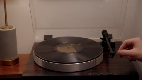 una persona poniendo un disco de vinilo para escuchar