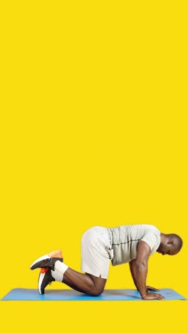 man demonstrating donkey kick exercise on yoga mat