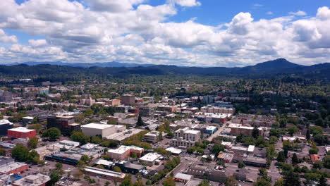 panoramic view of buildings and trees in eugene, oregon on a sunny summer day - aerial panning left