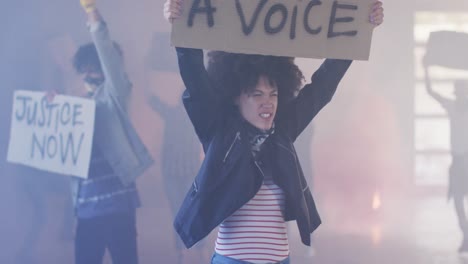 grupo diversificado de pessoas segurando cartazes de protesto gritando