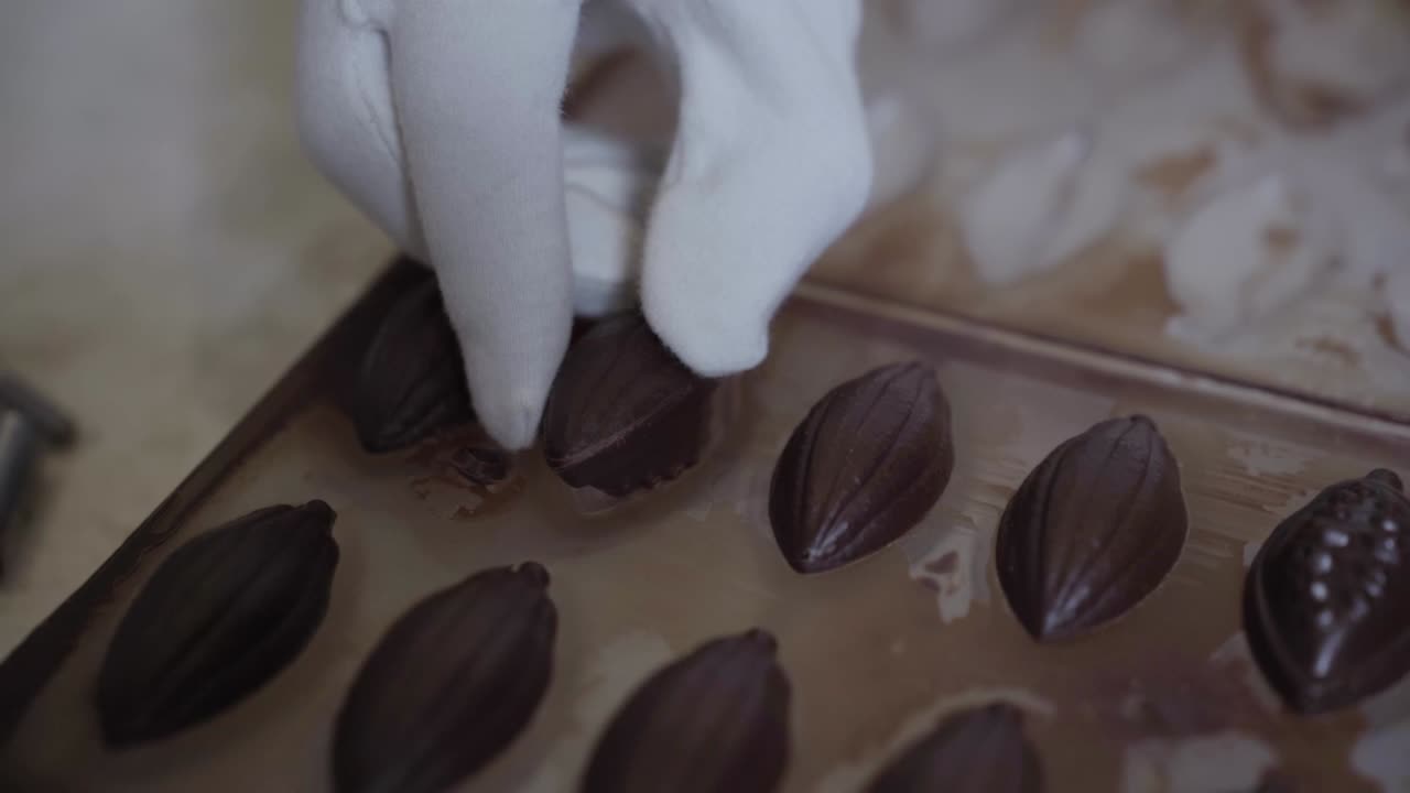 손바닥으로 이에서 수공예 초콜릿 조각을 제거하는 것