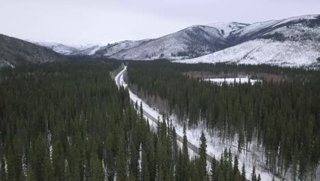 Aerial-View-of-Winding-Winter-Road-Through-Deep-Green-Trees,-Wintertime,-Alaska,-Chena-Hot-Springs-Road