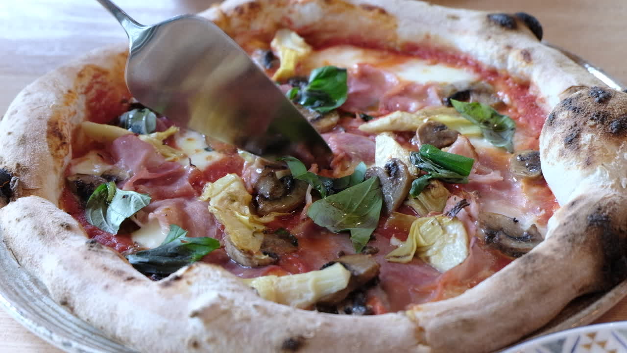 Donna che taglia una fetta di pizza su un tavolo in un ristorante