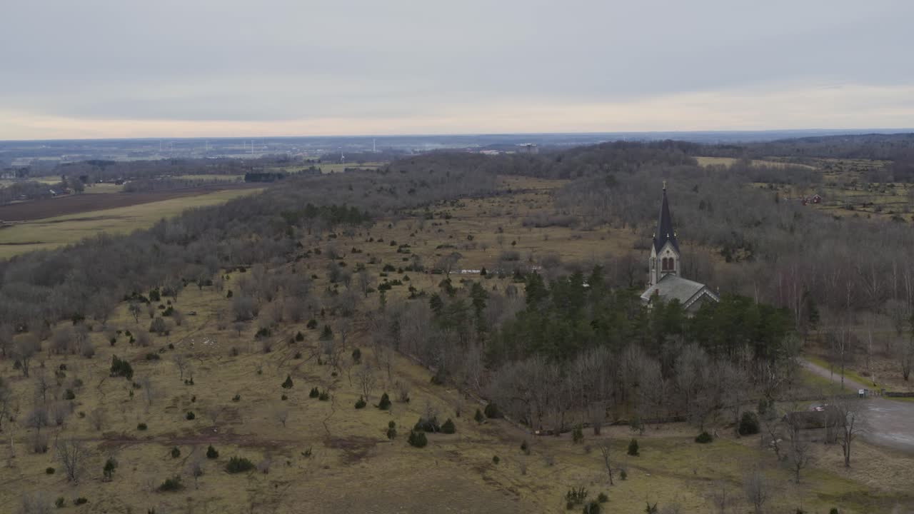 Pan up Aerial view drone flight winter landscape near church in Kinnekulle Sweden