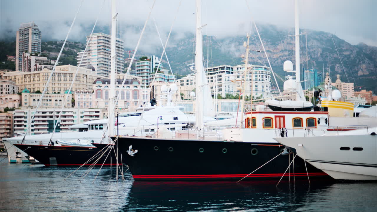 View of boats docked in the Monaco Marina with the skyline of the city on the background