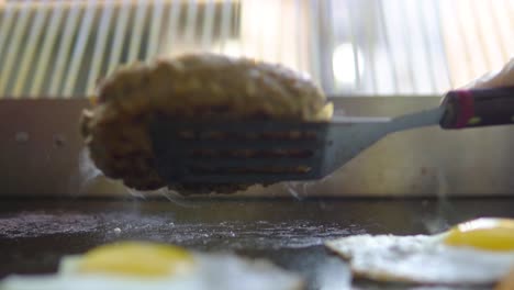 Flipping-and-pushing-down-burger-on-a-grill-in-fast-food