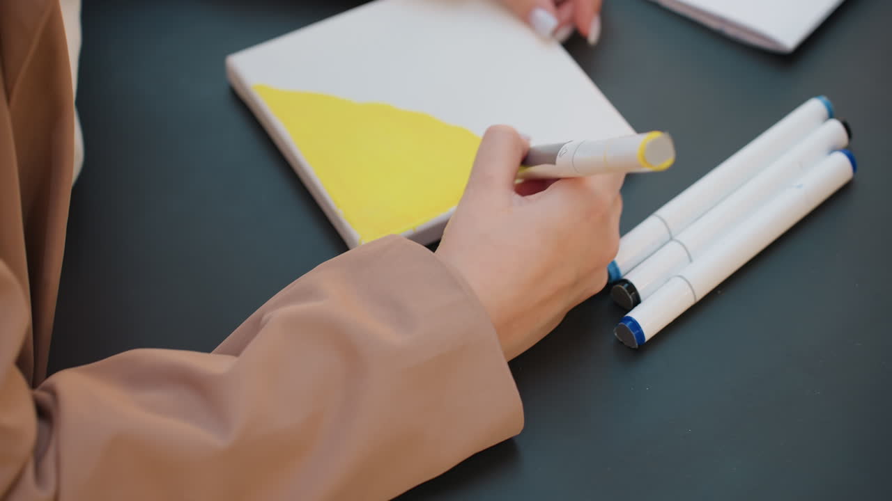 일정한 정확도로 스트로크를 다듬고, 면밀히 검사하면 마커 수정 작업에서 정확한 제어력을 확인할 수 있습니다. 아티스트가 마커 라인과 음영을 세심하게 조정하는 스튜디오 장면을 담았습니다.