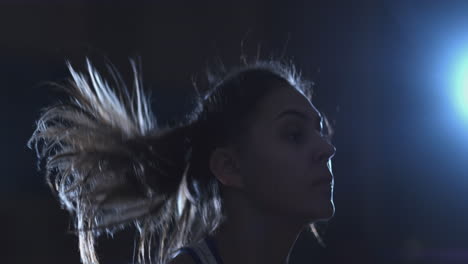 primer plano de la cara de una hermosa boxeadora saltando en una cuerda durante un entrenamiento de boxeo activo