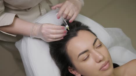 a focused treatment of mesotherapy on the scalp to enhance hair vitality, showcasing the precision and care of the medical practitioner