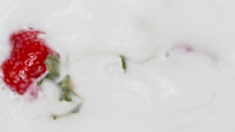 fresas rojas salpicando leche en cámara lenta