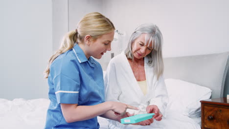 nurse helping senior woman to organize medication on home visit