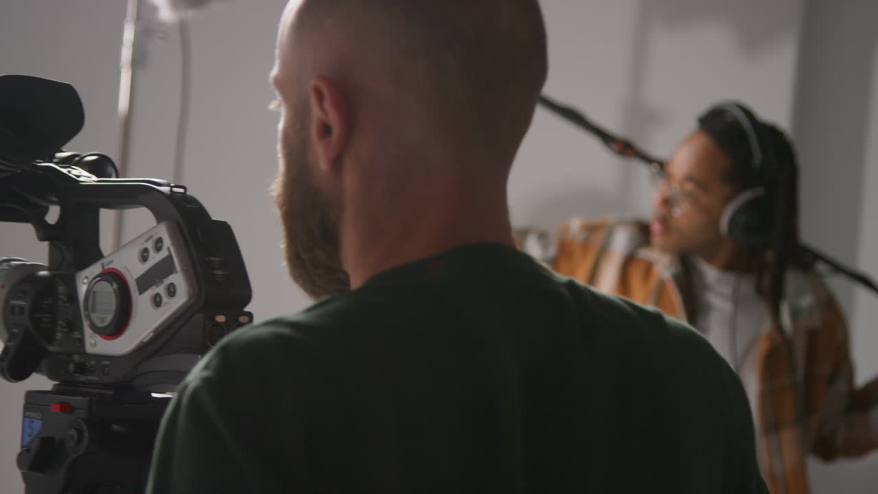 мужской звукозаписывающий и оператор камеры, работающий на съемочной площадке, снимающий фильм или видео в студии 3