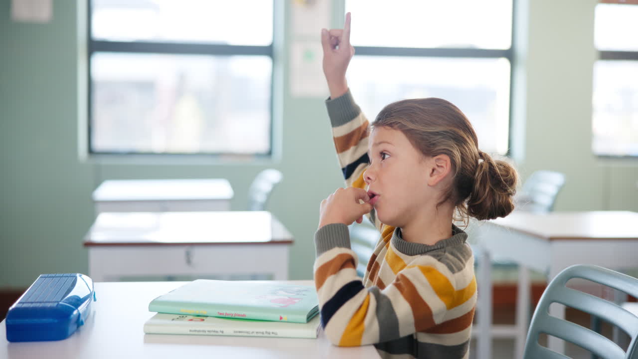 A child raising their hand in a classroom