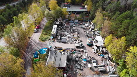 Metal-scrap-yard-full-of-different-pieces,-aerial-drone-view