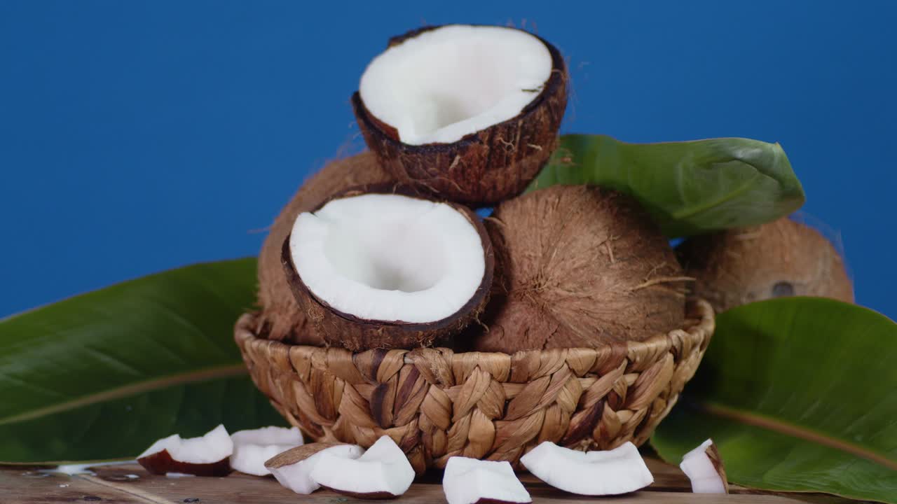 cocos frescos en la canasta con hojas girar lentamente.