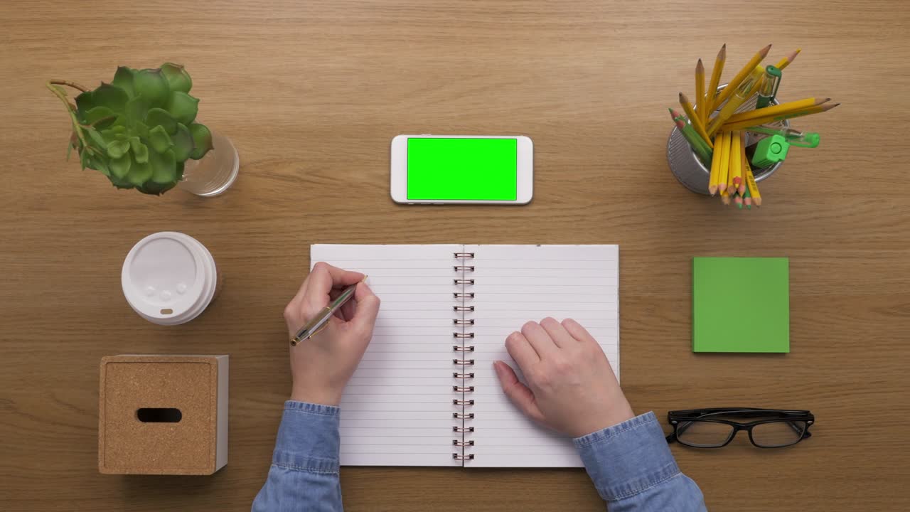 Overhead Top View Of woman Preparing To-Do List At Desk