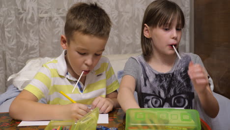 Niño-Y-Niña-Con-Paletas-Dibujando-Con-Lápices-De-Colores-En-Casa