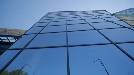 vista de bajo ángulo de una fachada de vidrio azul de un edificio moderno en estilo contemporáneo