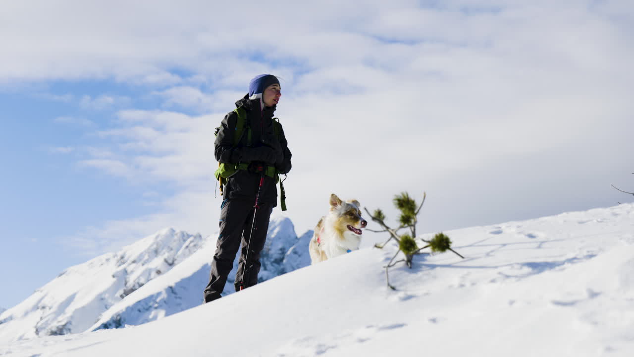 Woman and Dog Hiking in Snowy Mountains