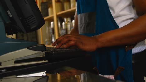 Mid-section-of-male-staff-working-at-counter-in-supermarket-4k