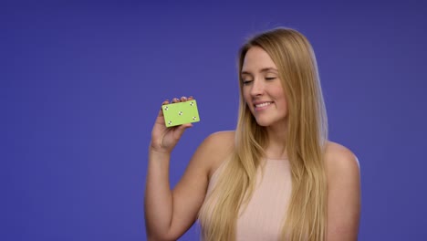retrato de una mujer hermosa sosteniendo una tarjeta en blanco en la cámara y dando una sonrisa impresionante