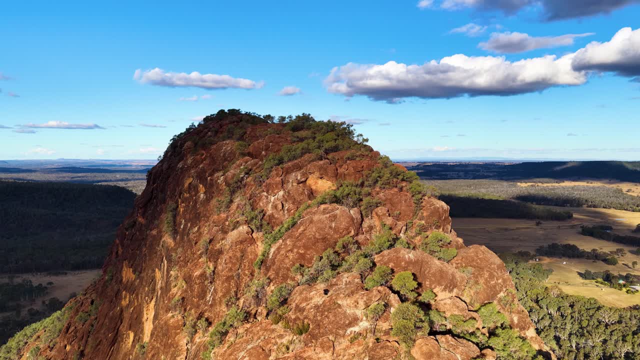 Drone glides over Timor Rock, revealing rugged volcanic outcrop and vast Australian landscape at sunset