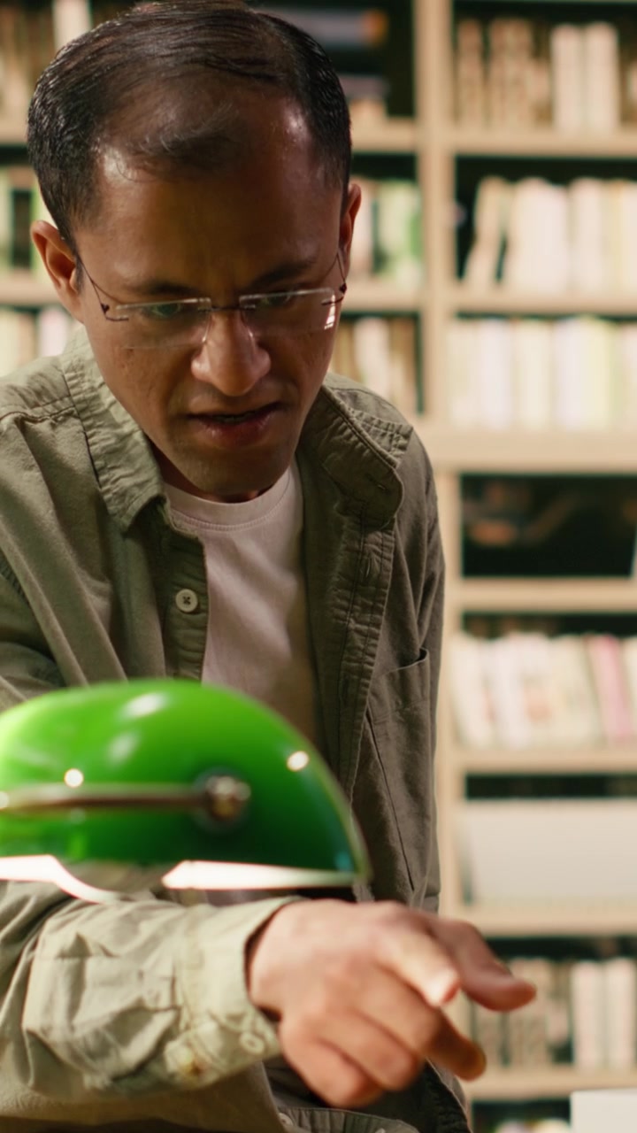 Vertical Video Tutor discussing study notes with woman student at library desk