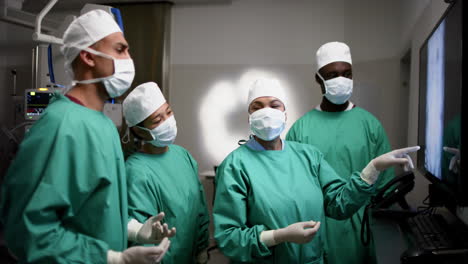 diversos cirujanos discutiendo con escáneres de rayos x en el quirófano del hospital, en cámara lenta