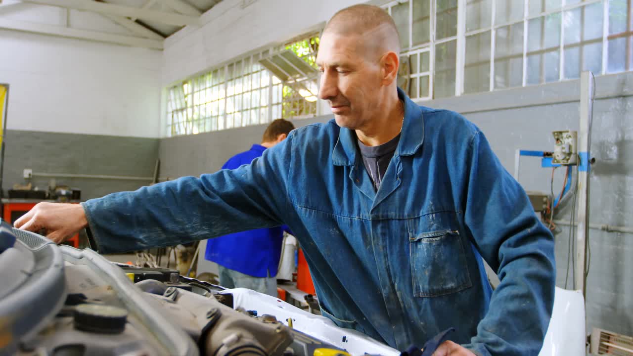 mecánico examinando un coche 4k