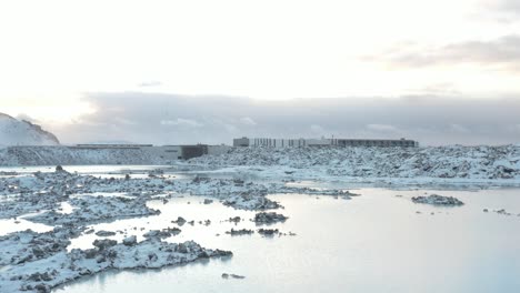 Calm-water-of-Blue-Lagoon-in-Iceland-with-volcanic-rock-covered-in-snow