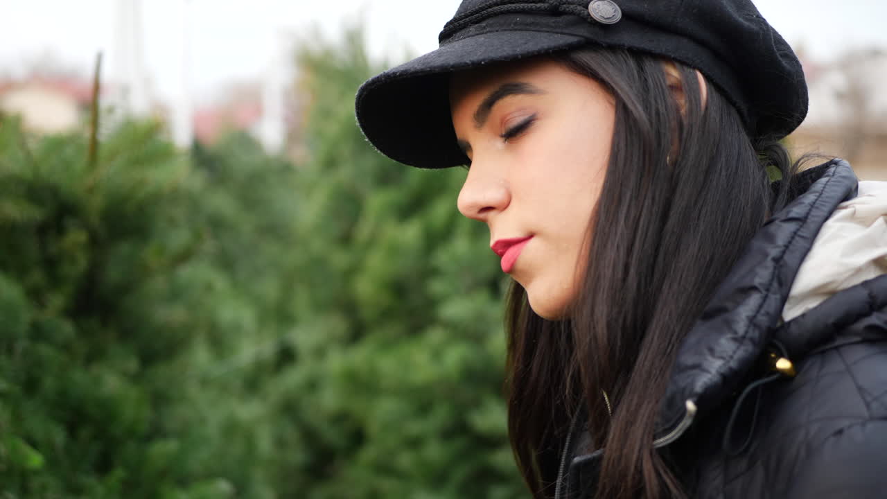 계절별 명절 보육원에서 녹색 전나무 침엽수가 있는 크리스마스 트리에서 쇼핑하는 히스패닉 여성