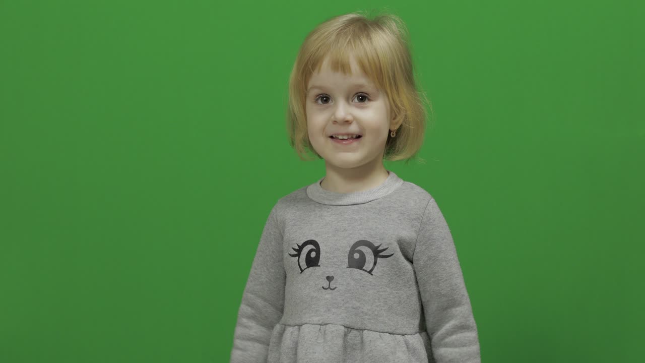 niña en una pantalla verde, llave de croma. feliz niña de tres años