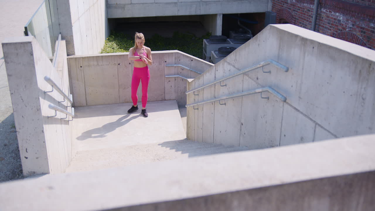 una hermosa joven en forma hace el entrenamiento de cardio en la escalera en un entorno urbano