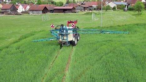 tractor cerca de un campo de fútbol y casas da marcha atrás y luego se aleja