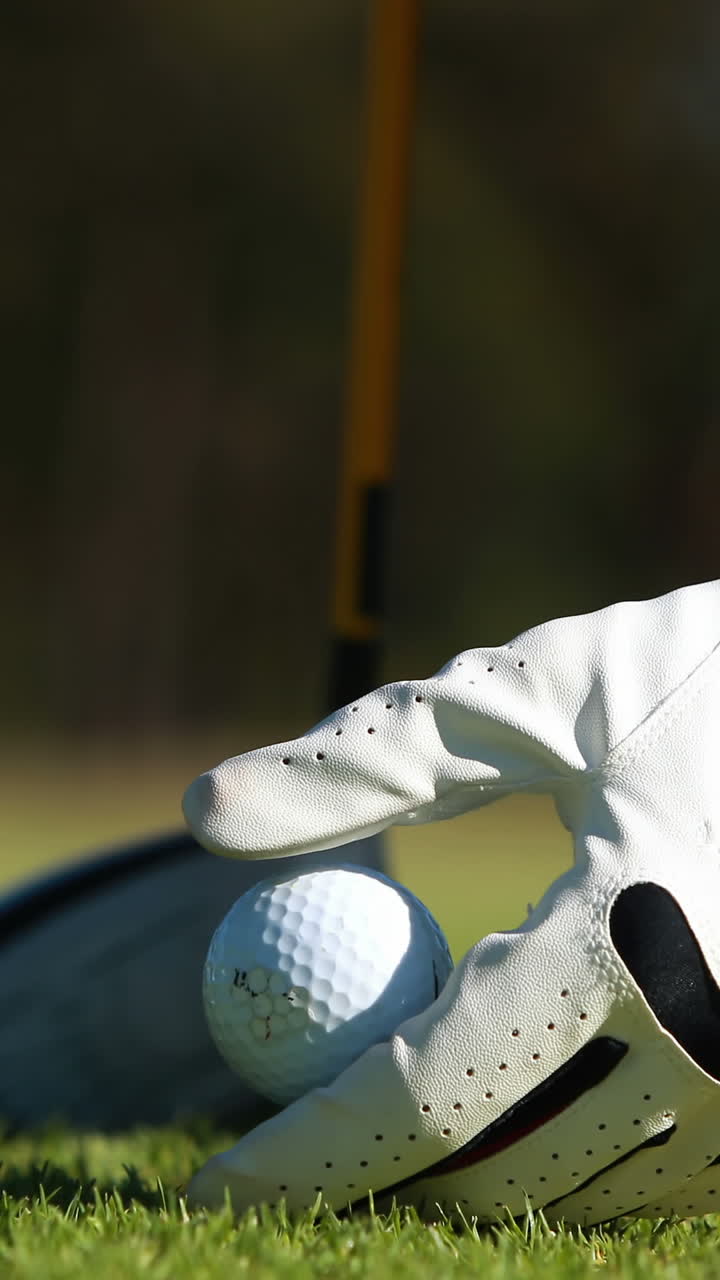 Giocatore di golf che dispone palla da golf sul tee