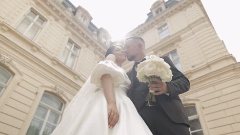 newlyweds portrait, caucasian groom bride walking, embracing, hugs near old castle, wedding couple