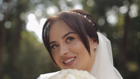 novia en vestido de boudoir sentada en el jardín de la mañana con un ramo de rosas, mujer en vestido de noche velo