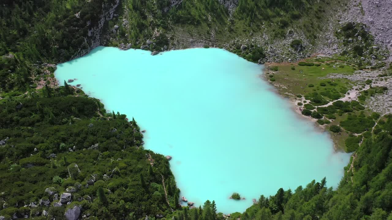 Lake Sorapis bright turqoise water in the Dolomites Italy, rising tilt down aerial
