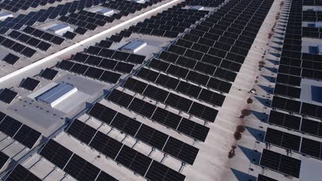 solar panels installed on a roof of a large industrial building or a warehouse. industrial buildings in the background. horizontal photo.