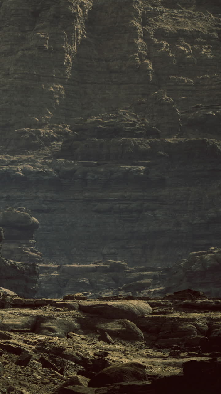 Majestic cliffs rise above serene landscape during golden hour glow