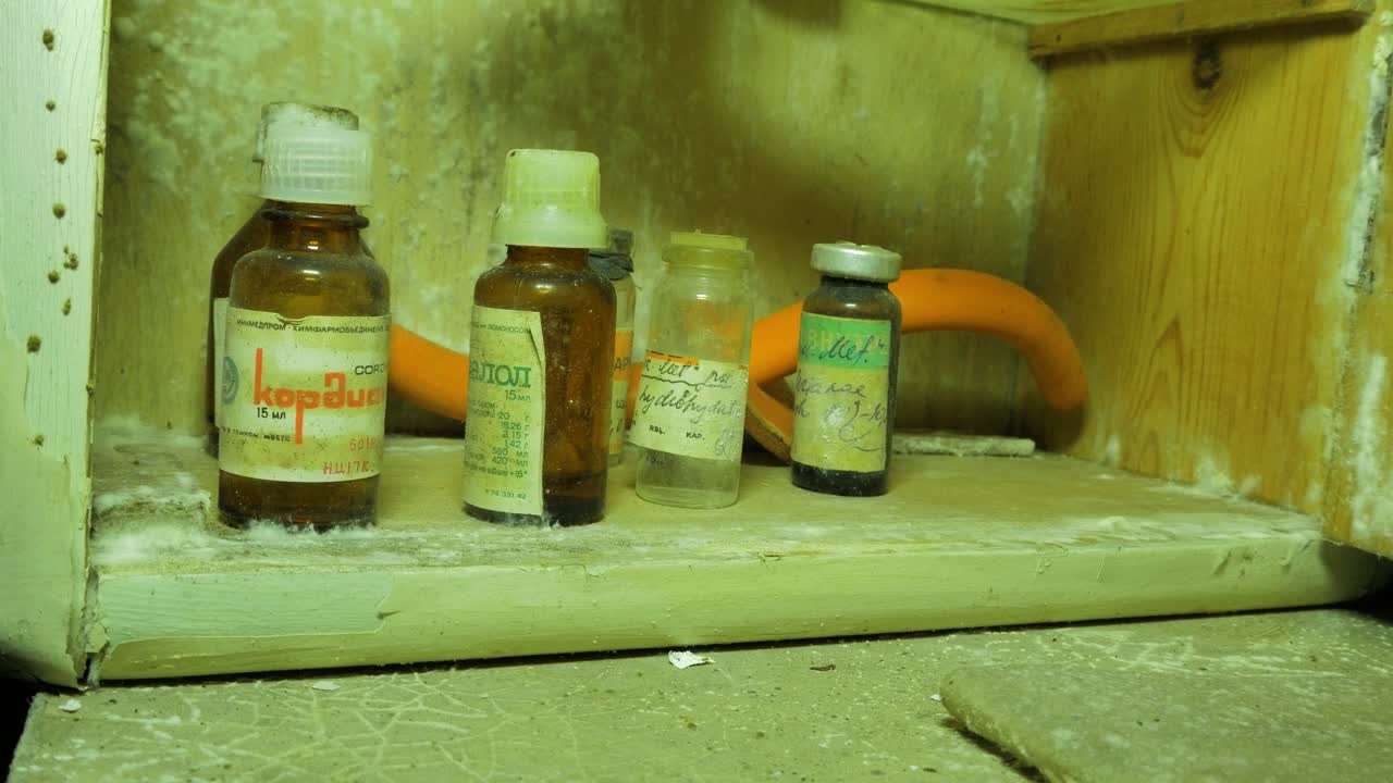 viejas botellas médicas, accesorios dentro del refugio antibombas subterráneo soviético abandonado, antiguo búnker de la guerra fría soviética, apocalipsis, primer plano de mano