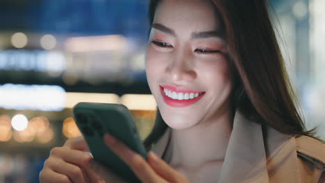 mujer usando teléfono inteligente por la noche