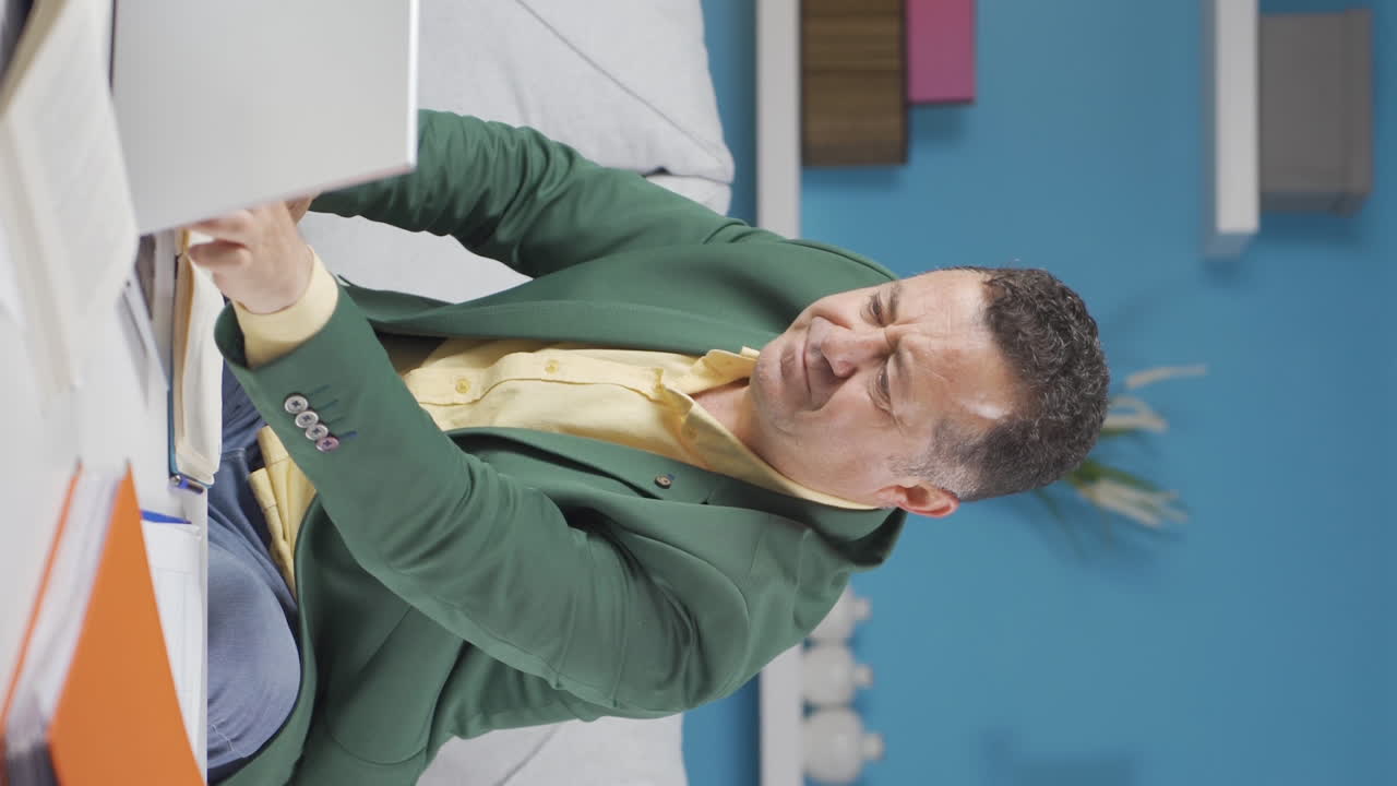 vídeo vertical de un trabajador de oficina en casa, un anciano pensando creativamente.