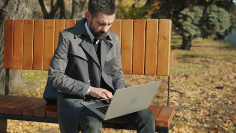 businessman working on laptop in park