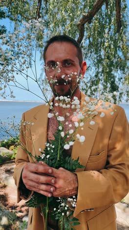 man with flowers by the river